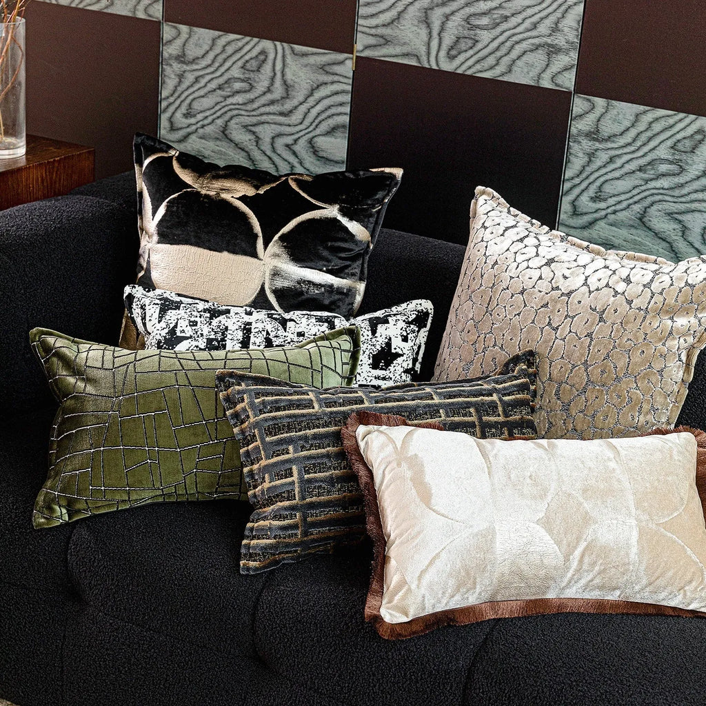 Black and gold abstract patterned flannel decorative cushion on a grey sofa.