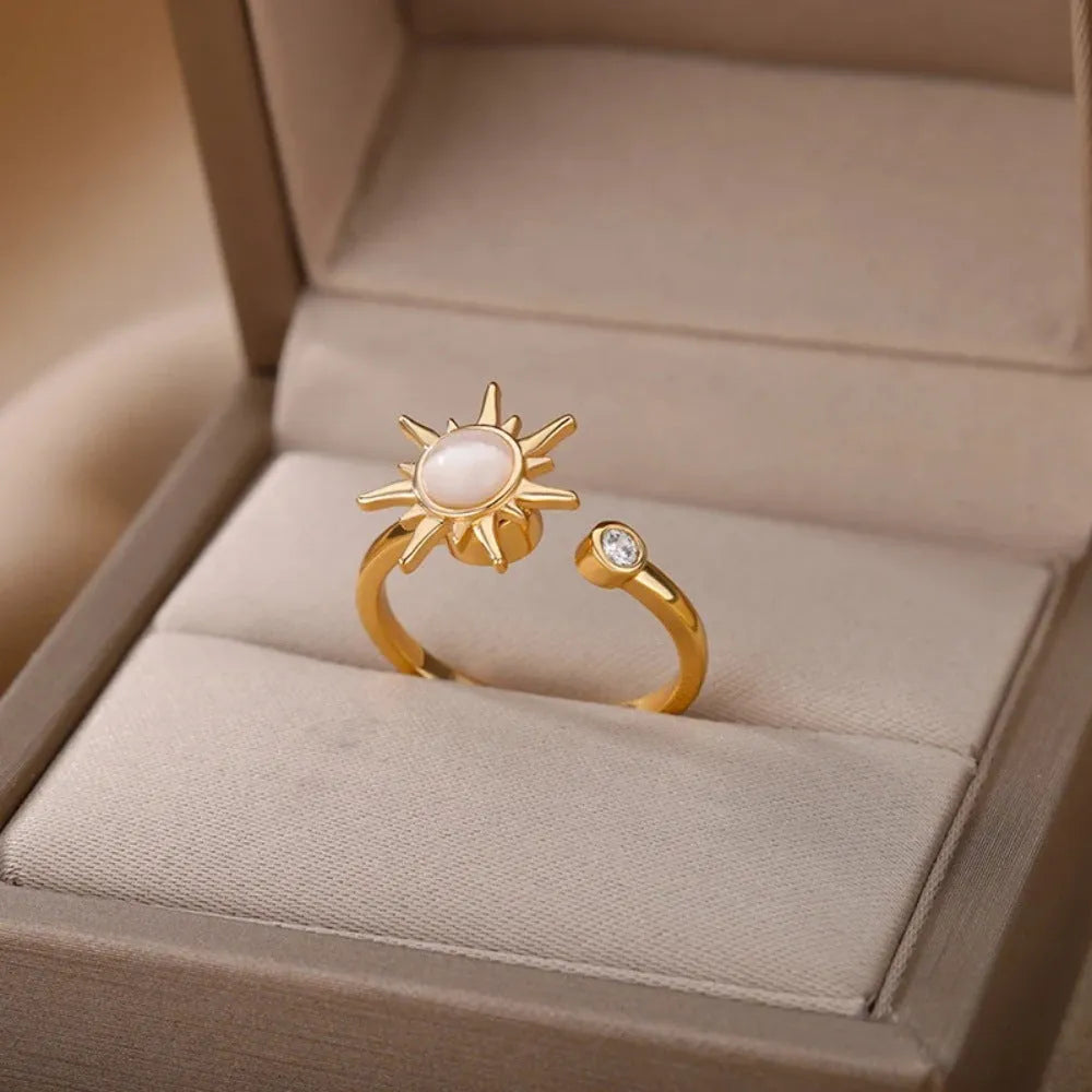 Gold and platinum coloured adjustable geometric decompression ring with rotatable element on a white background.