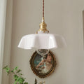 Medieval brass flower bud design glass chandelier hanging from a ceiling, shown in a light blue colour variant.