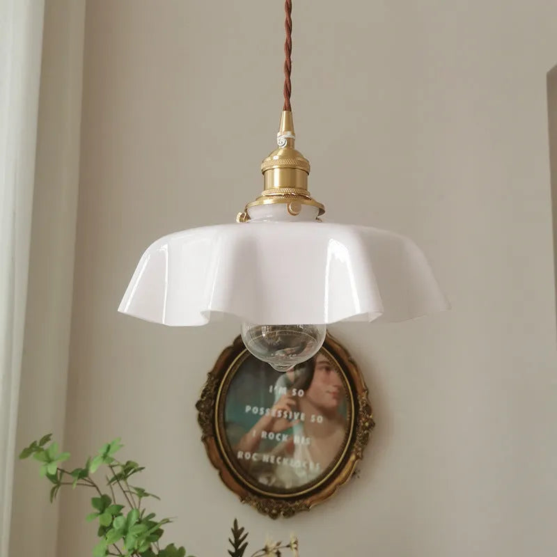Medieval brass flower bud design glass chandelier hanging from a ceiling, shown in a light blue colour variant.