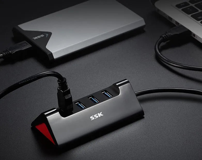 Black USB expansion dock with four ports, compact rectangular design, and a Micro USB power cable.