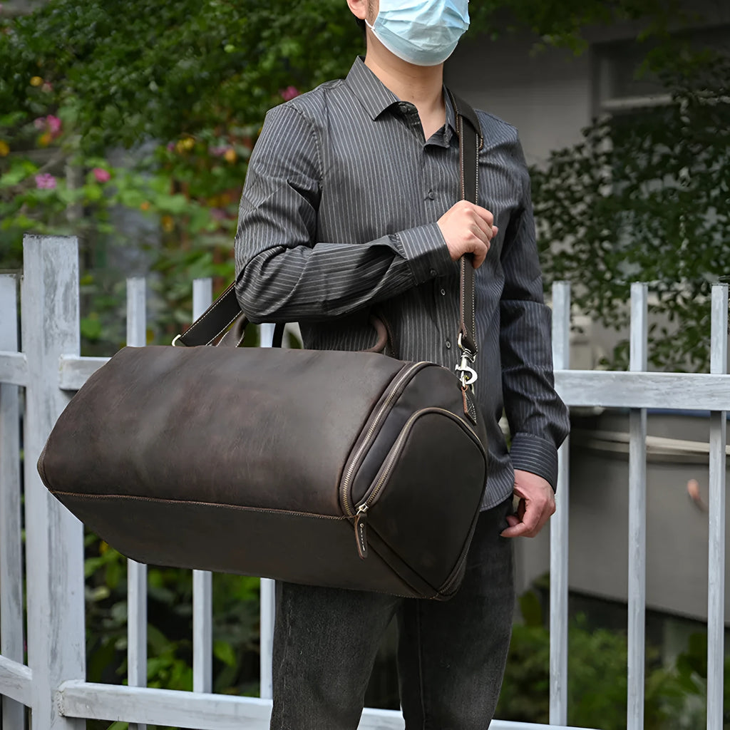 Vintage 22 inch brown leather duffle bag made from top layer cowhide, folding design with zipper closure on plain background