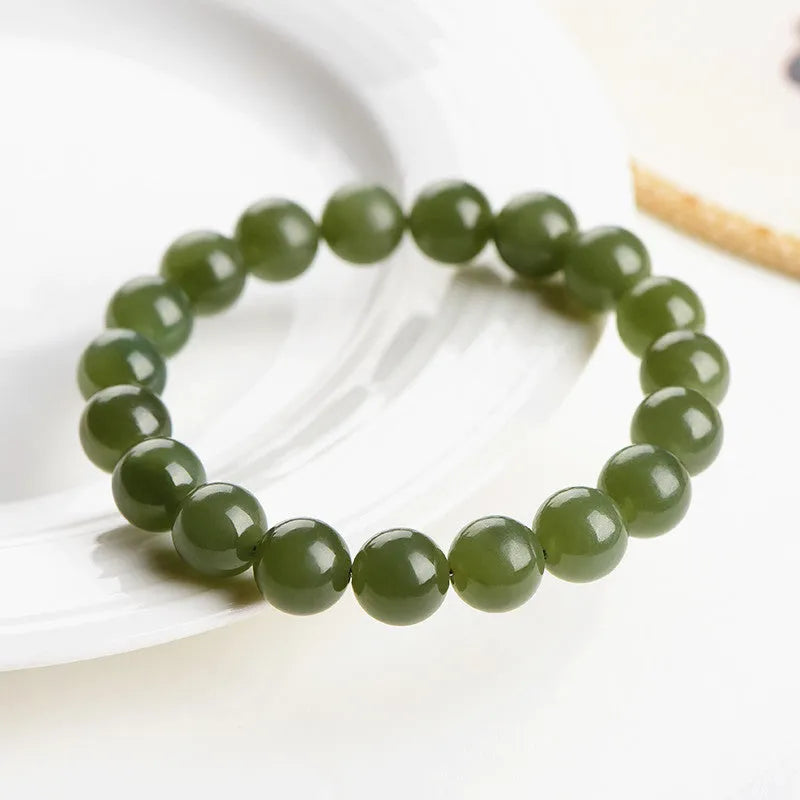 Polished Hetian jade ball bracelet in ice clear colour on a wrist, showing spherical beads.