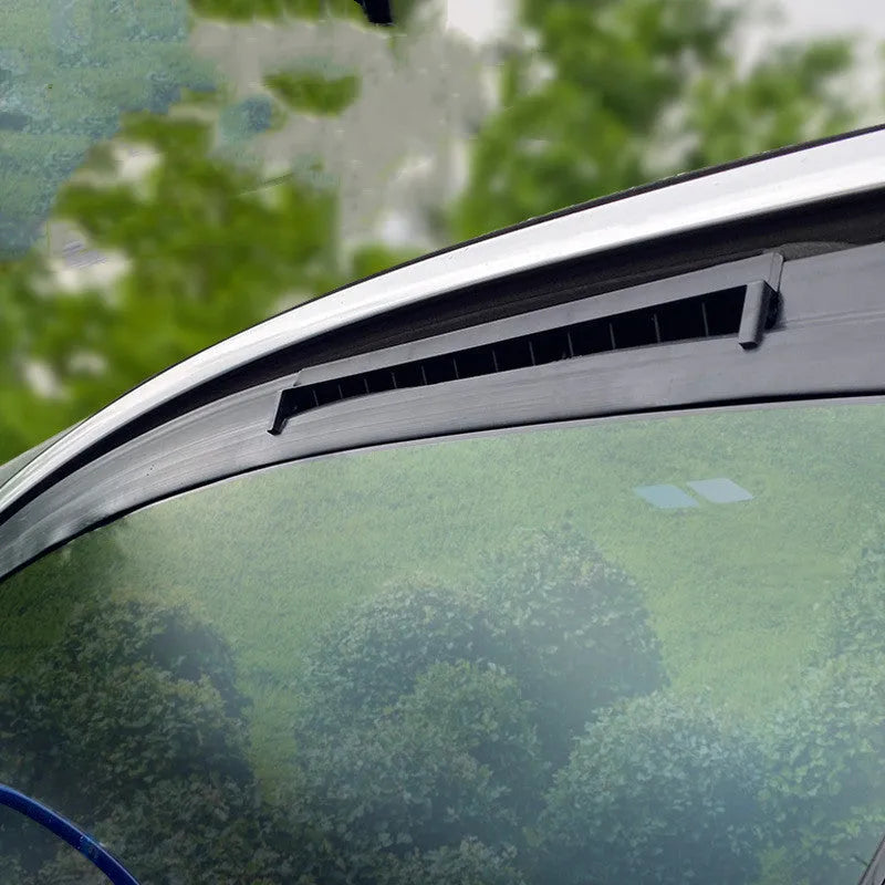 Black and white portable USB car ventilation fan on a car dashboard with power cable.