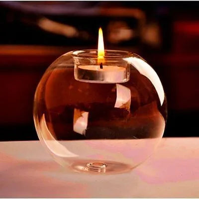 Clear handmade round hollow glass candleholder on a table.