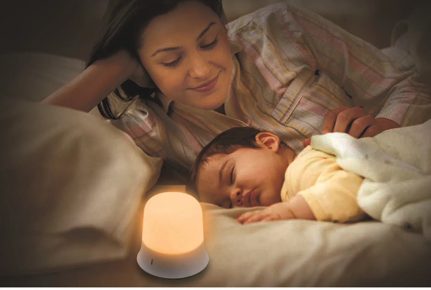 White cylindrical bedside night light with touch controls on a wooden surface.