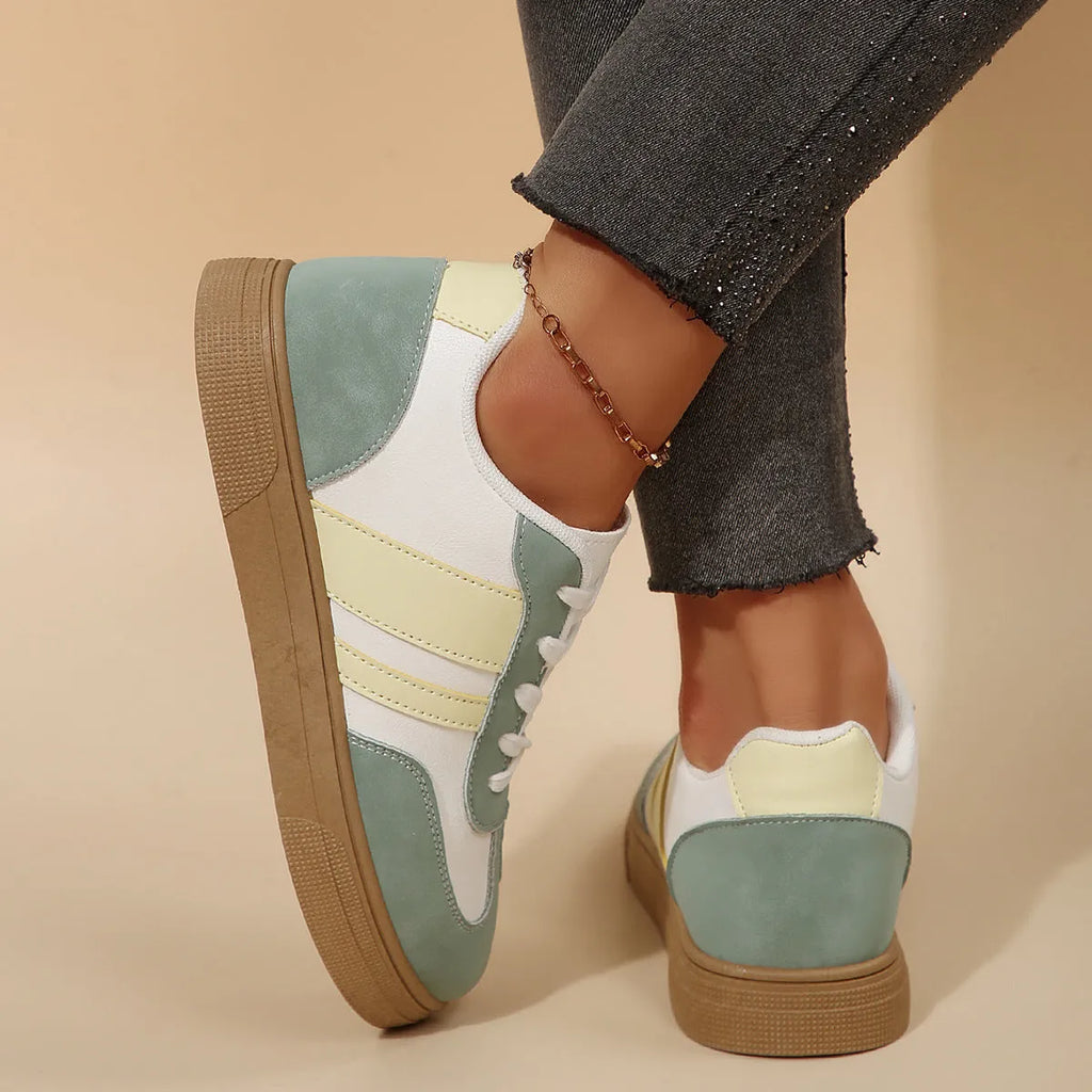 Women's green retro sports shoes with white cross straps, low top, flat rubber sole, and round toe.