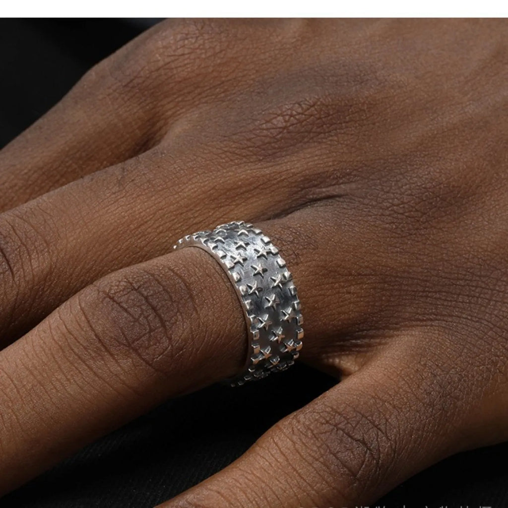Adjustable opening sterling silver ring with a geometric pattern of several five-pointed stars.