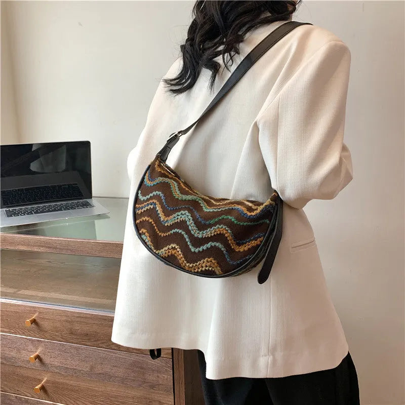 Women's straw woven crossbody bag showing texture and internal phone and file compartments.