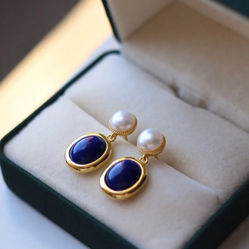 A pair of simple sterling silver earrings featuring a blue lapis lazuli pearl and auspicious patterns.
