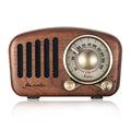 Retro wooden mini Bluetooth speaker in cherry wood finish on a table.