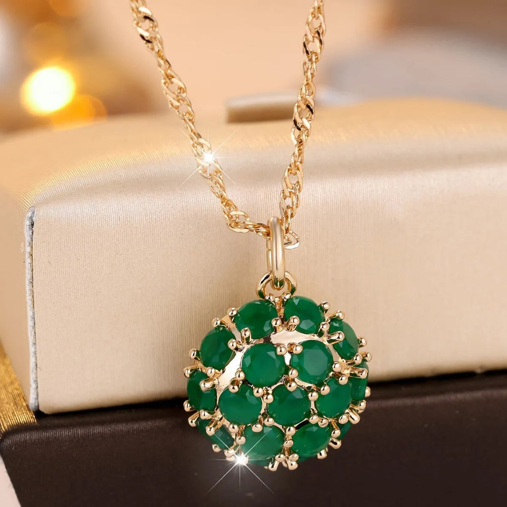 Round pendant necklace with emerald diamond elements on champagne gold electroplated chain