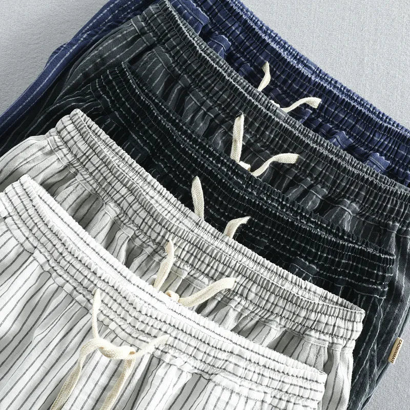Man wearing striped cotton shorts with an elastic waistband in a light grey colour.