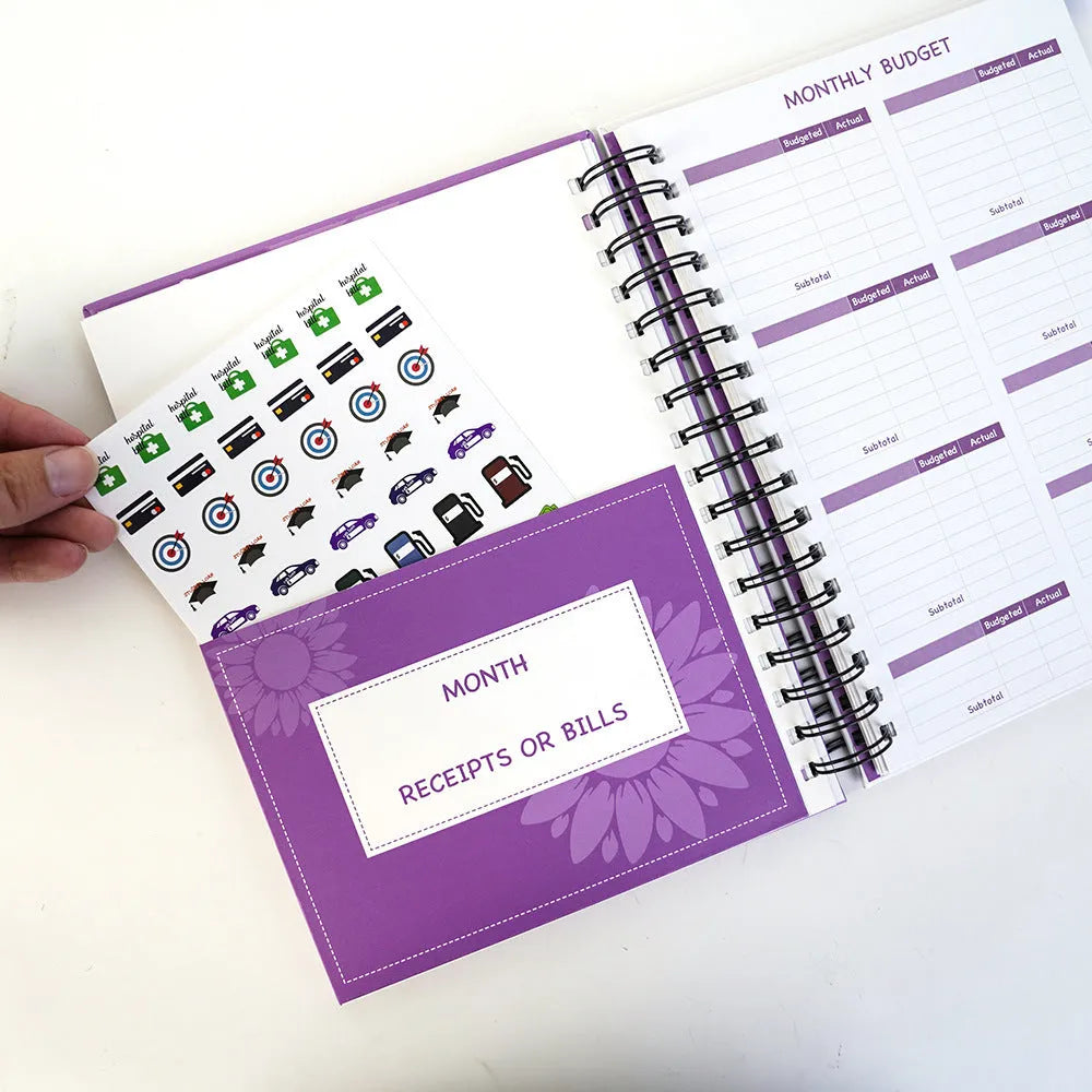 Purple coil-bound budget book set with pen, stickers and paper clips for financial planning