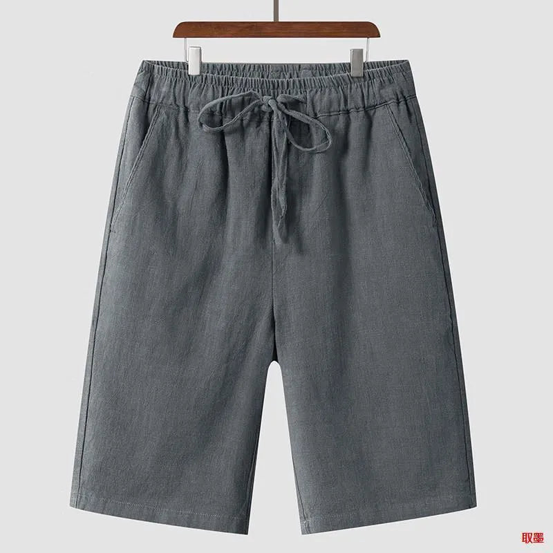 Man wearing beige linen casual shorts with a loose, cropped fit and elasticated mid waist.