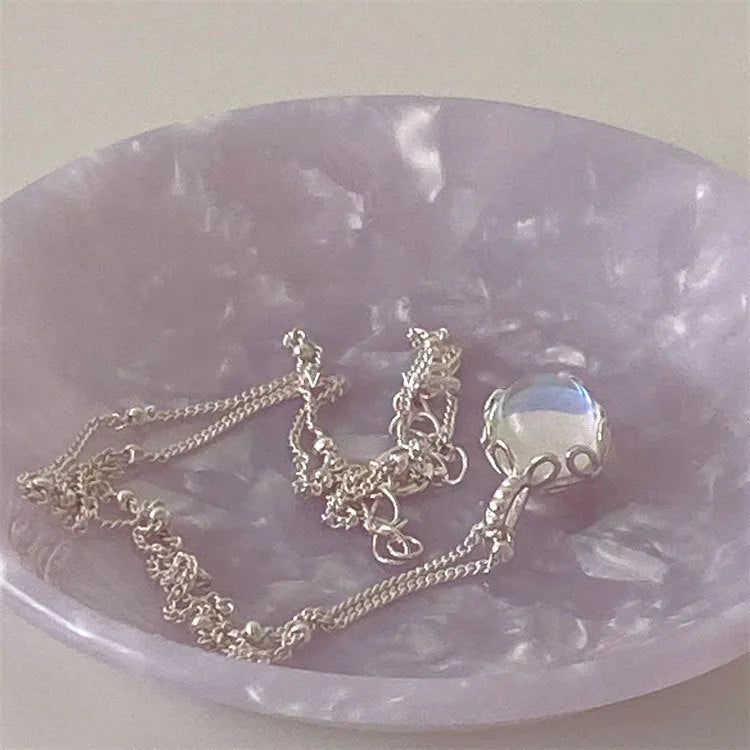 Women's sterling silver necklace with round geometric pendant on an adjustable curb chain.