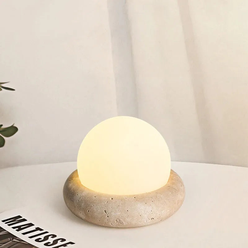 Cream coloured bedside night light with remote control on wooden table