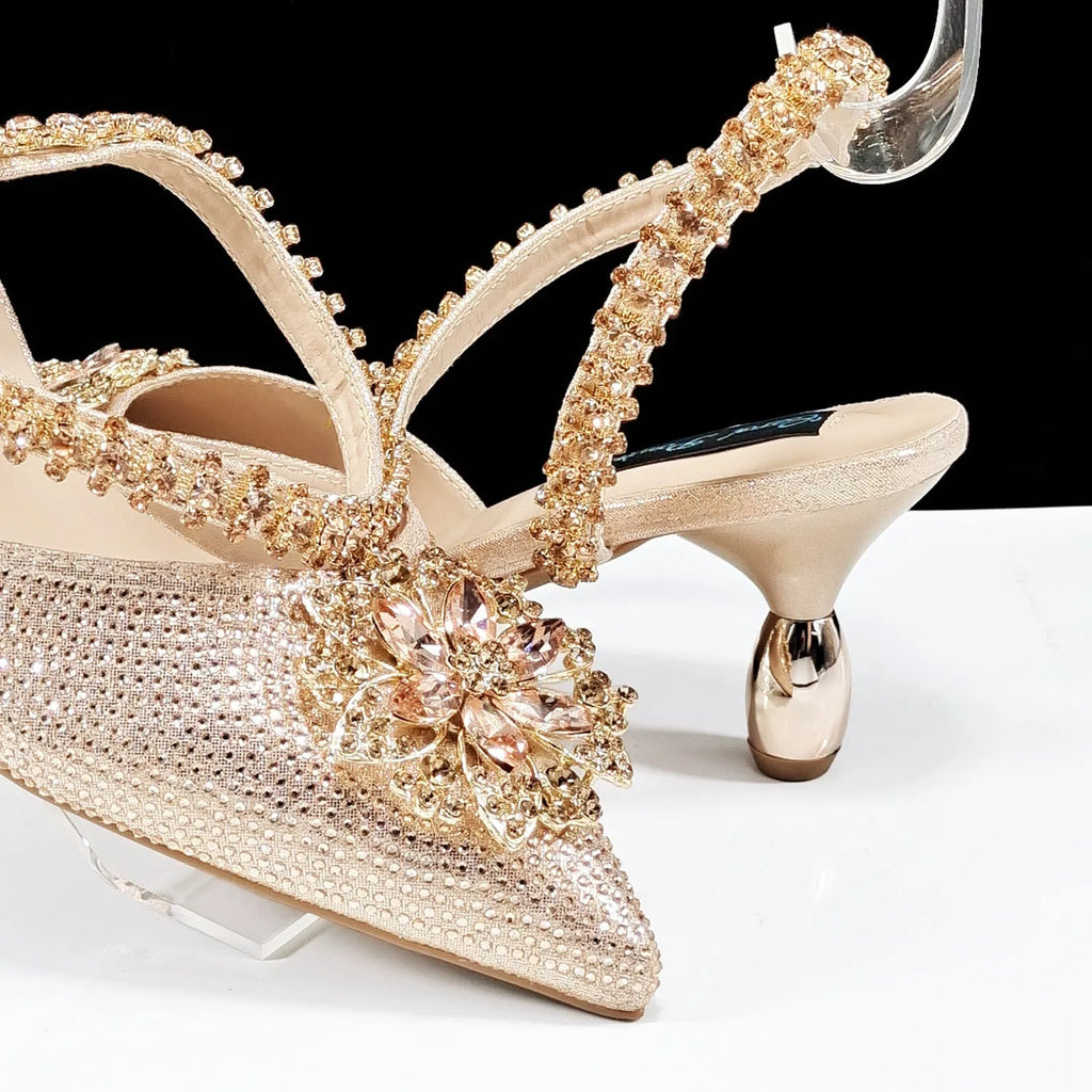 Women's black high heel ankle strap sandal with rhinestone flower and matching clutch bag.