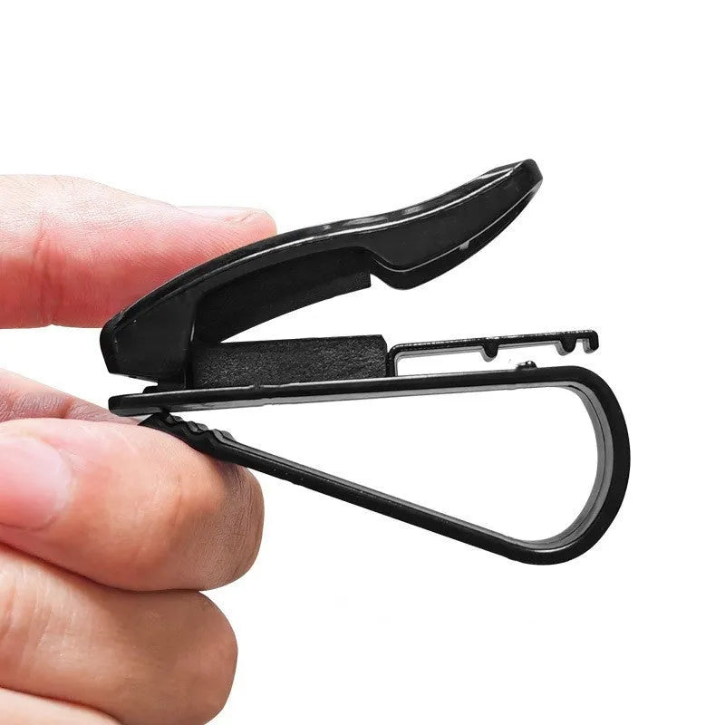 Black plastic multifunctional clip for car sun visor to hold sunglasses, tickets, and ID cards.