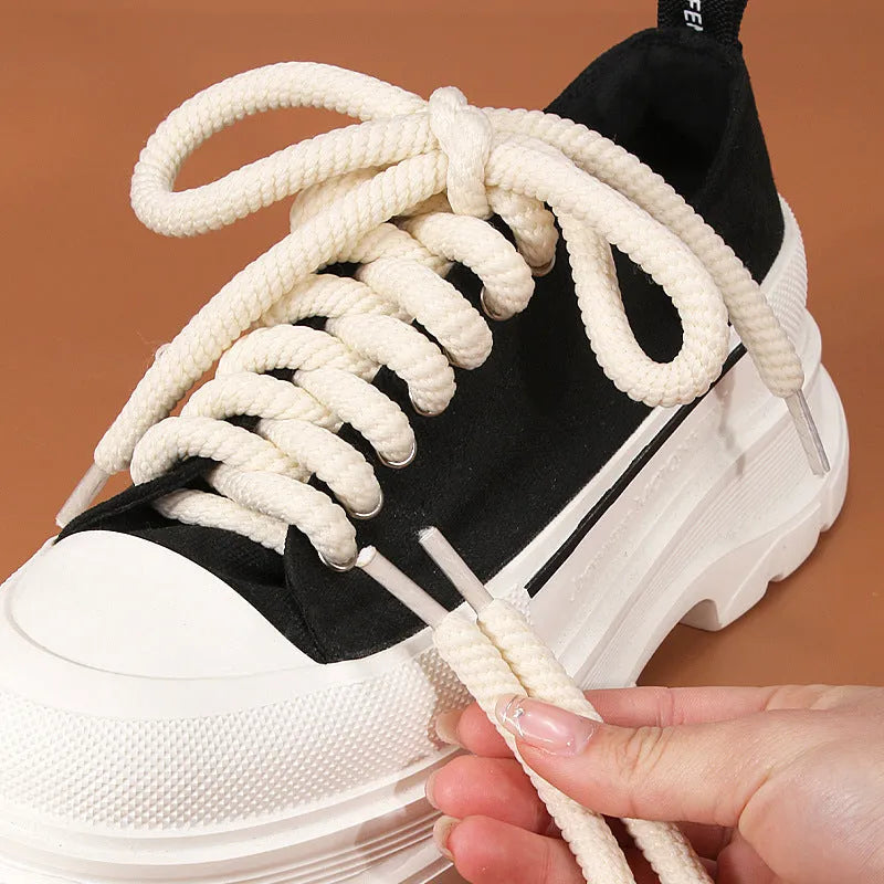 Round white woven shoelace on a grey background showing its 10mm diameter and textured weave.