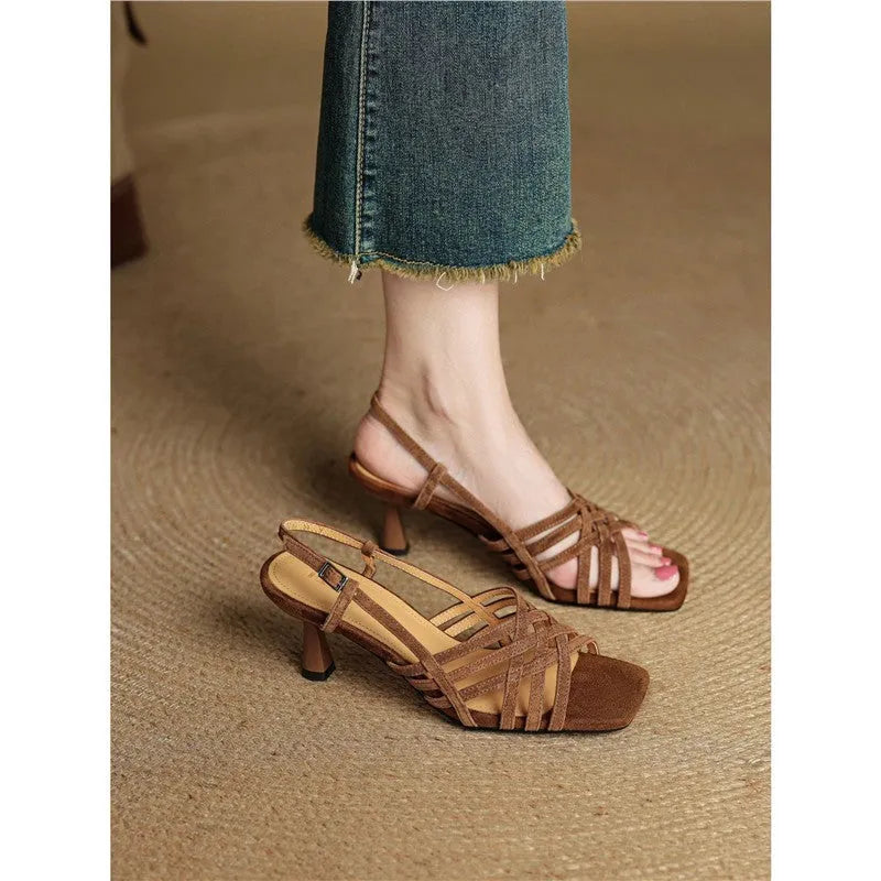 Retro women's sandals with thin cross straps, ankle buckle, and a mid heel in light brown.