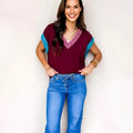 Burgundy loose V-neck sweater with contrast trim on short cuffed sleeves