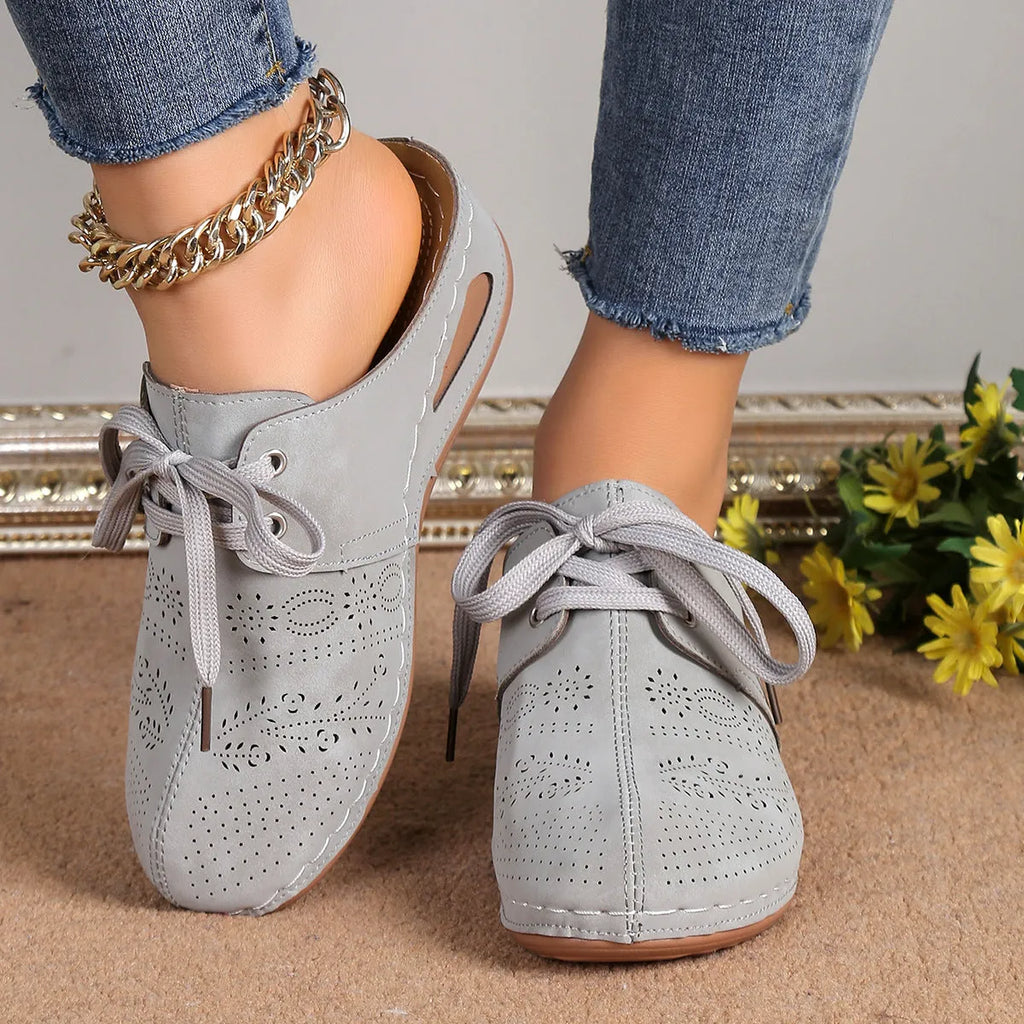 Women's black lace-up wedge slippers with suede upper and hollow-out design on a rubber sole.