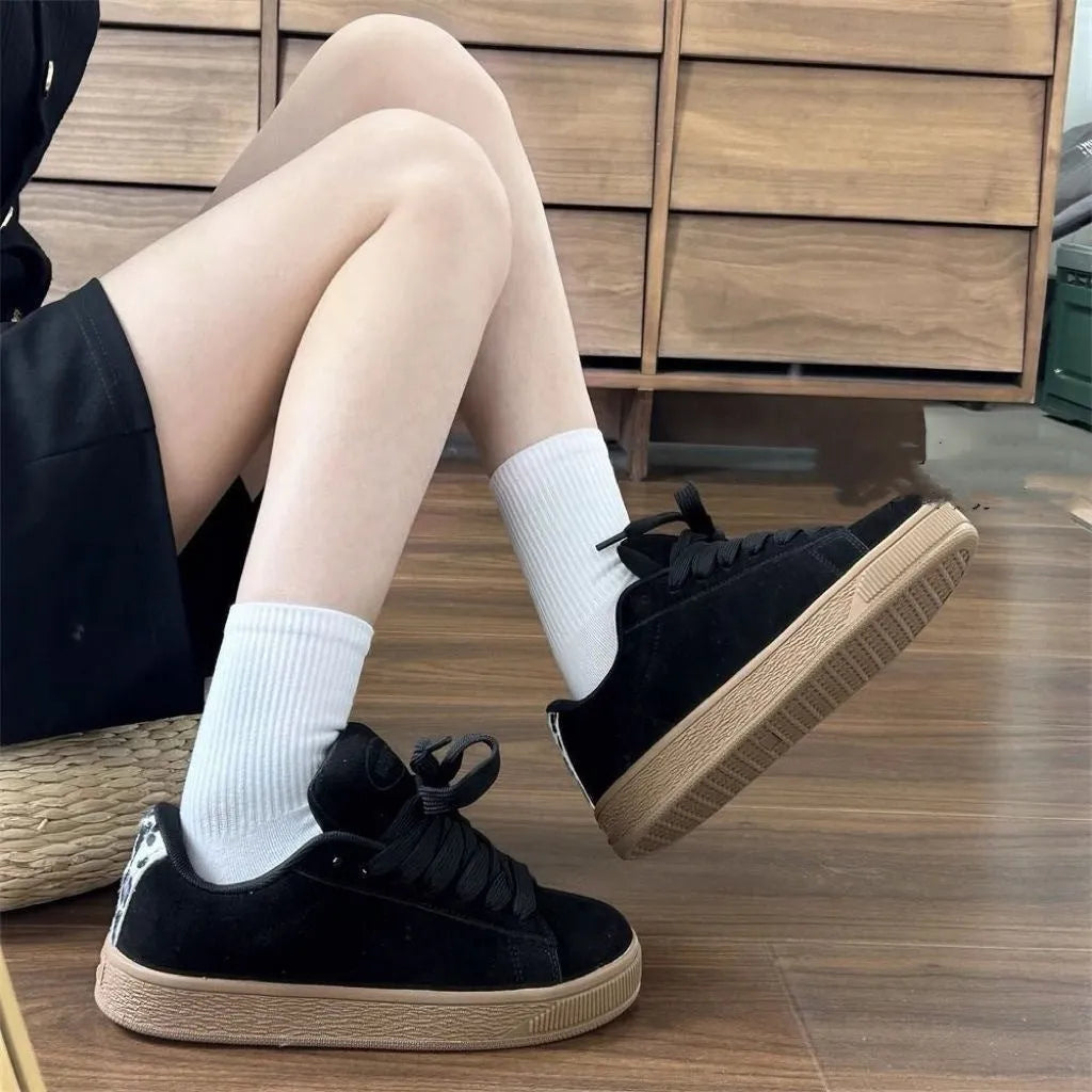 Black retro low-top sneakers for men and women on a white background, showing round toe and lace-up design.