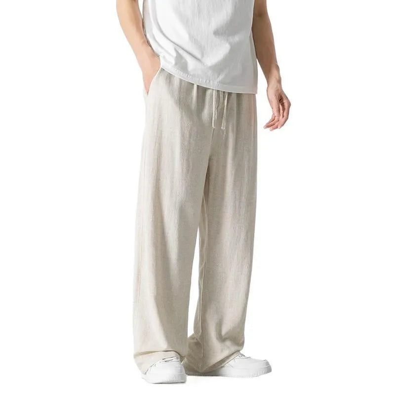 Men's beige loose-fit linen-style bamboo fibre trousers with a cropped leg and drawstring waist laid flat.