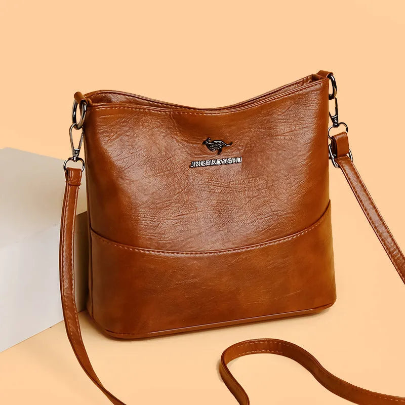 Women's black bucket-style leather shoulder bag with sewing line detailing and shoulder strap