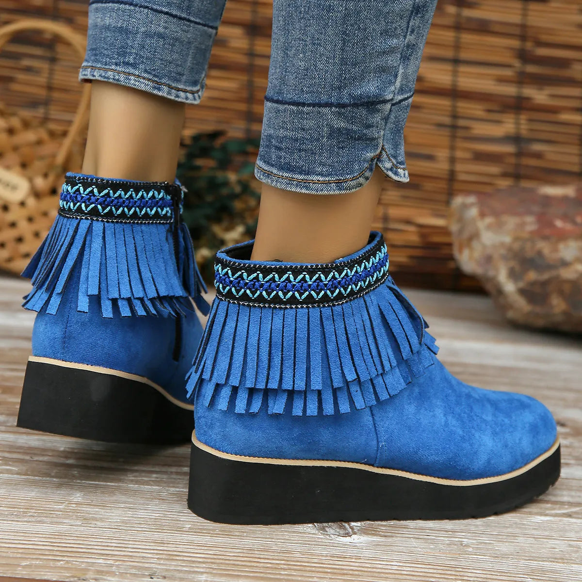 Women's dark brown suede wedge ankle boot with side zipper and tassel detail on a thick rubber sole.