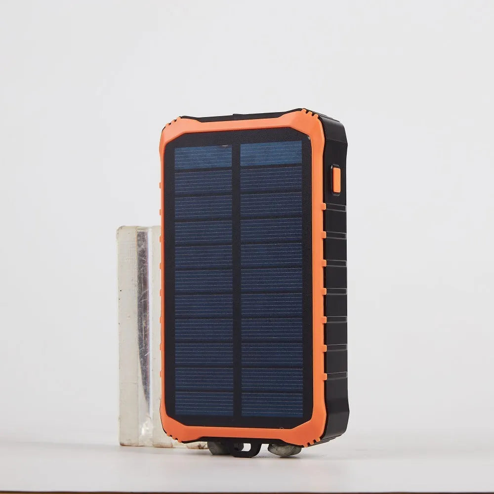 Orange and green hand crank solar power bank with 12000mAh capacity showing USB ports and LED torch