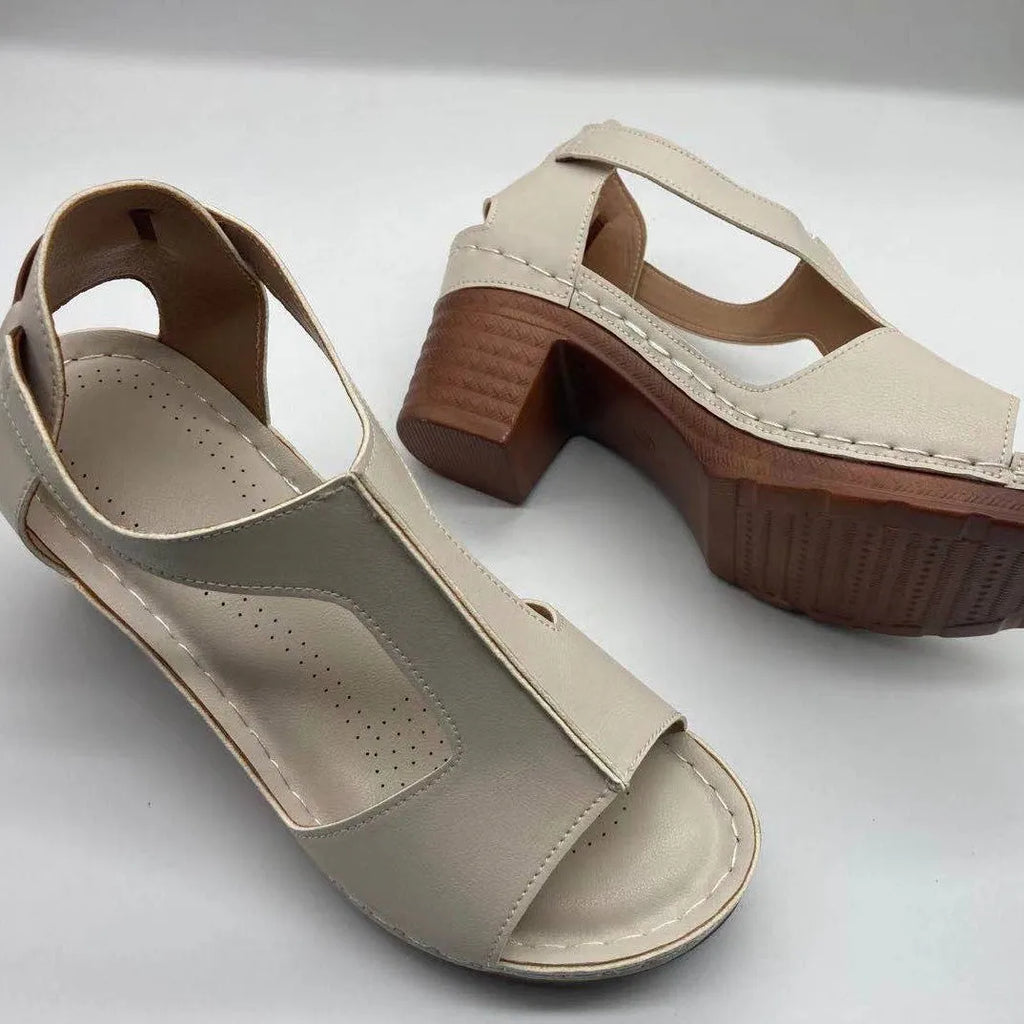 Women's white peep toe wedge sandals with a buckle and low heel on a neutral background.