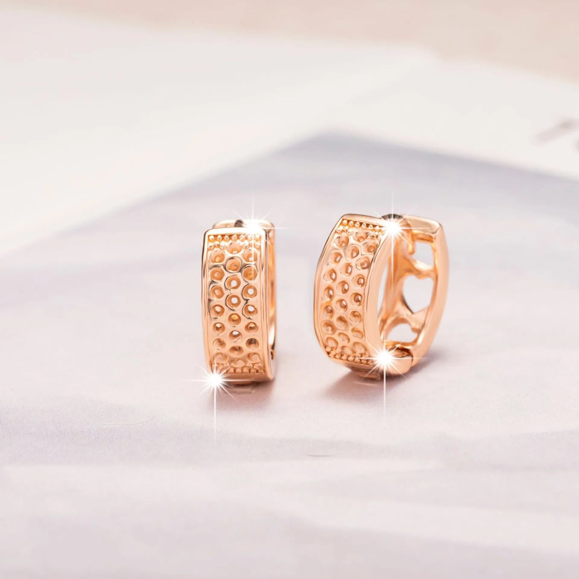 Rose gold hollow heart earrings with three open sections and circular shape