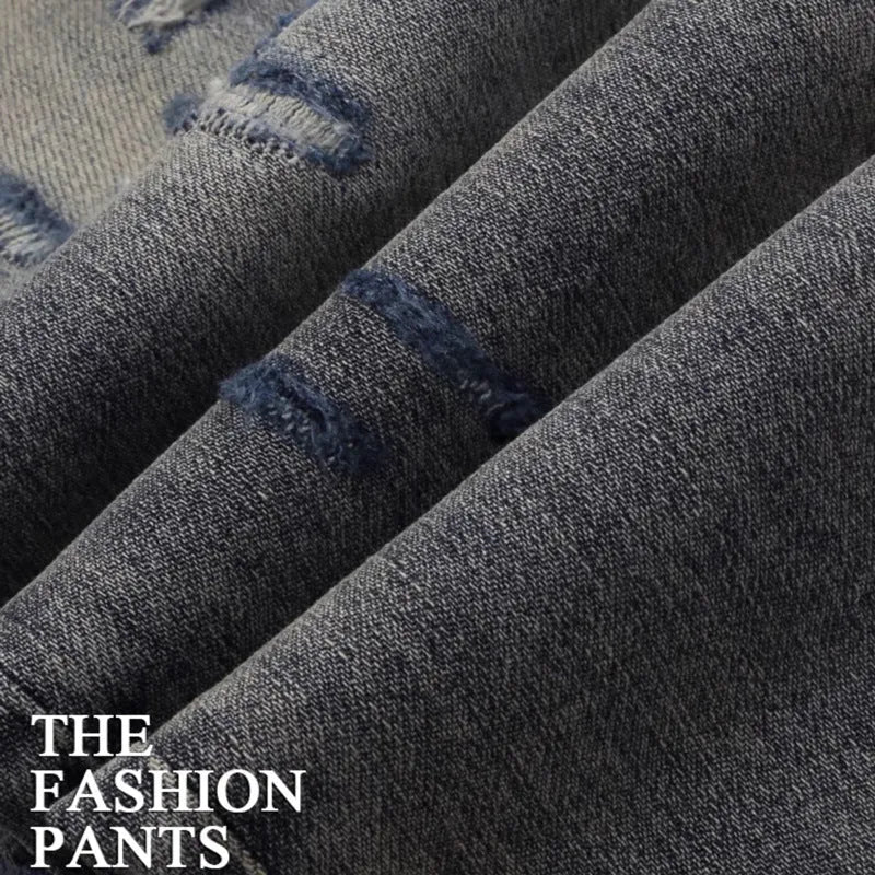 Slim fit light blue jeans with worn patches and embroidery on the legs, showing a washed-out colour.