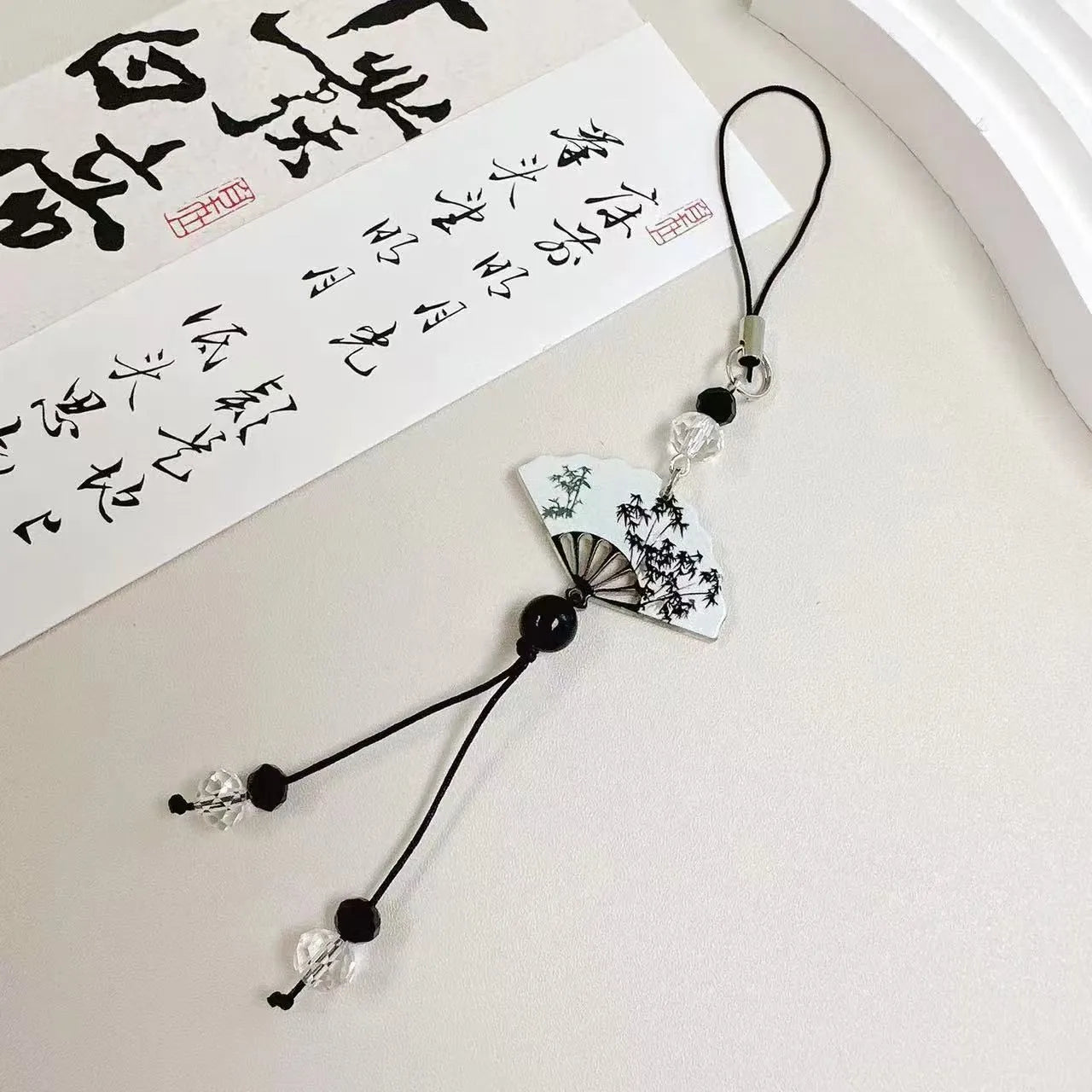 Guofeng Chinese style bead pendant keychain with detailed plant and flower pattern in a glossy finish.