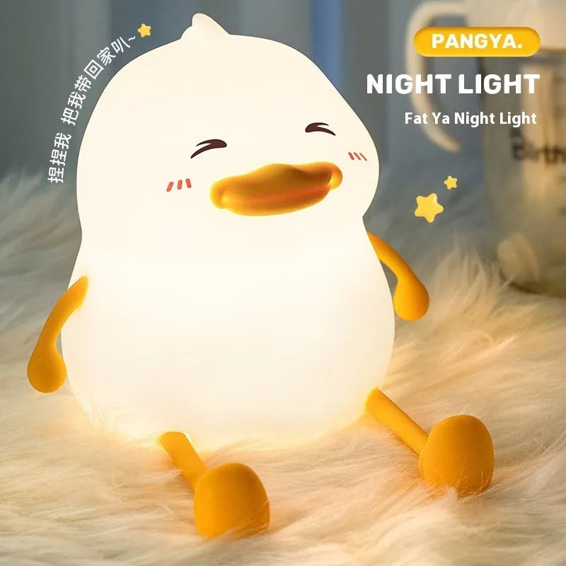 Chubby white USB rechargeable LED night light with built-in silicone phone holder on its base.