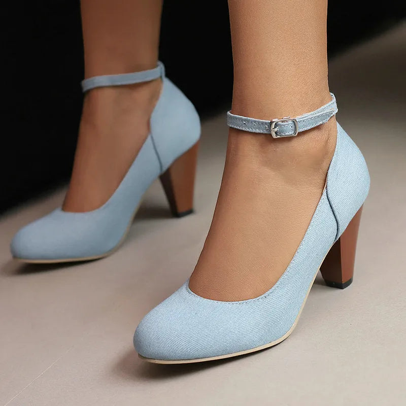 Blue denim women's ankle boots with a buckle strap and thick platform heel on a rubber sole.