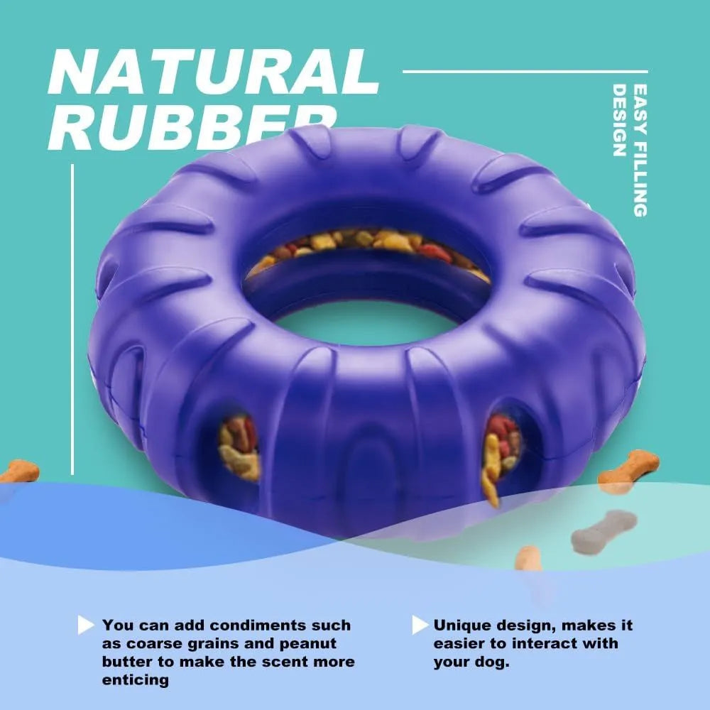 Blue rubber tyre-shaped dog chew toy and slow feeder with oval openings on a wooden floor.