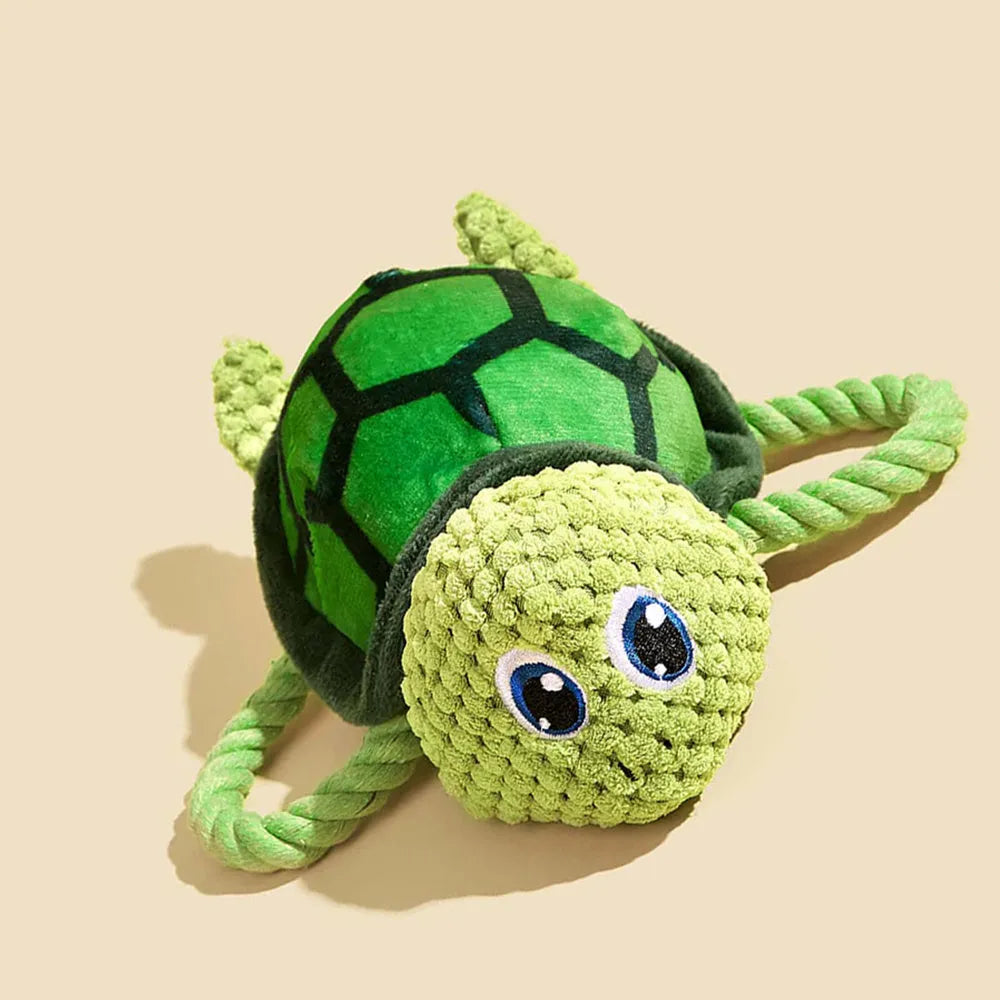 Grey turtle-shaped knot toy for dogs with a built-in squeaker on a plain background