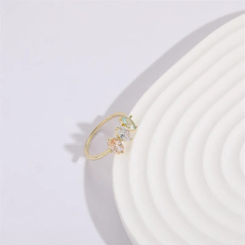 Geometric triangle birthstone ring with tricolour zircon and horse eye motif in gold plating.