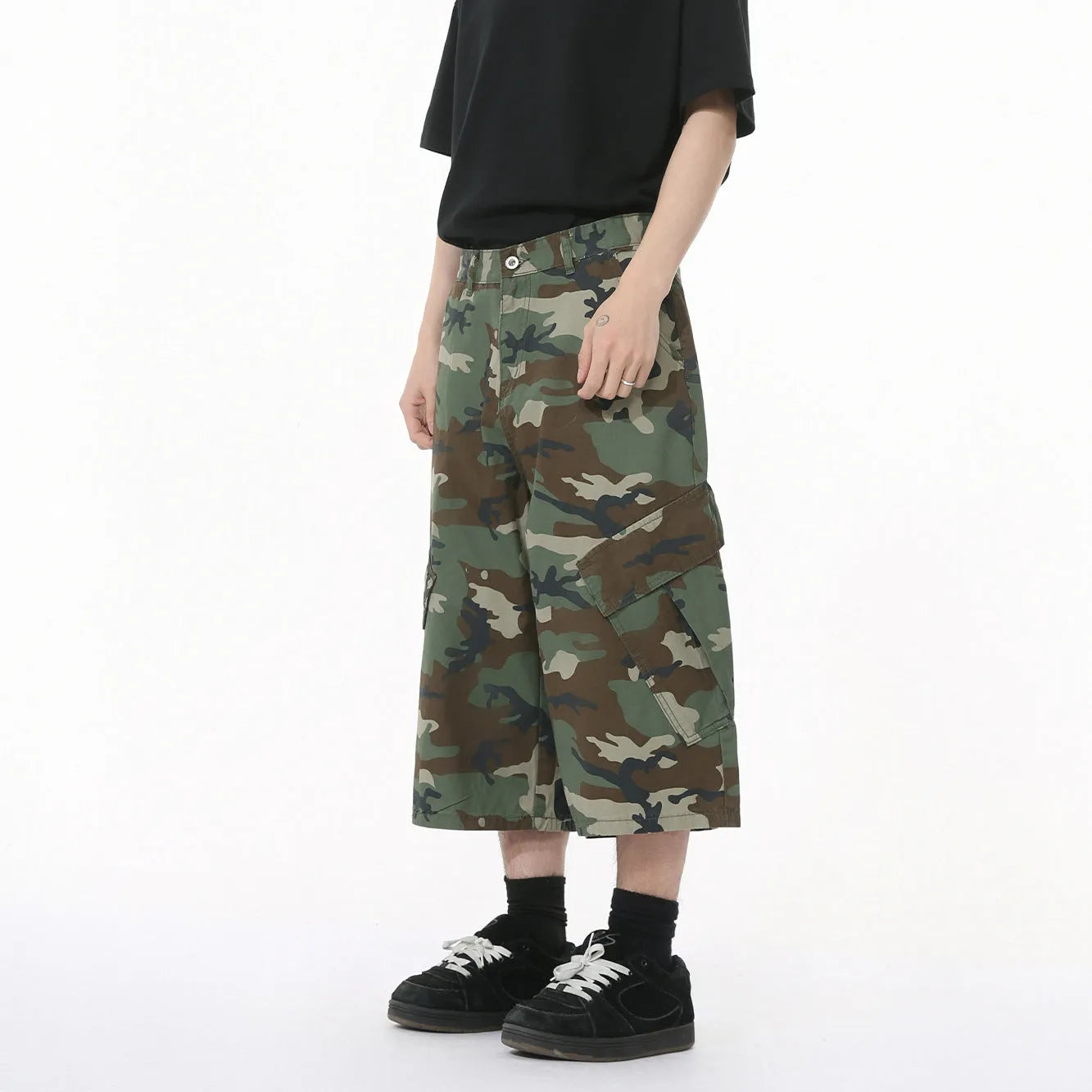 Men's green camouflage cotton trousers with wide loose legs, large side pockets, and cropped length