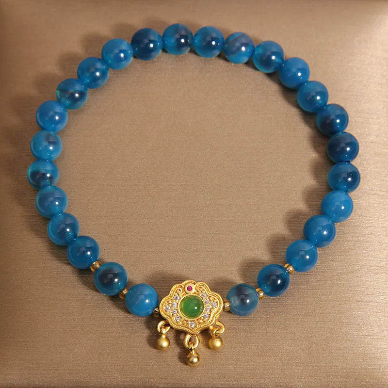 Blue sugar heart agate and jade safety lock pendant on a women's crystal bracelet with alloy inlay.