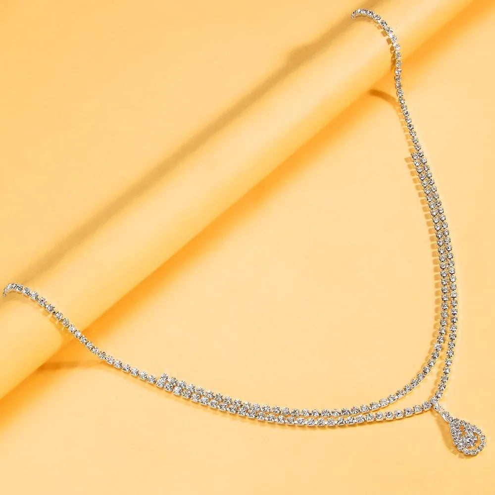 Women's gold rhinestone waist chain with water drop pendant and tassel details