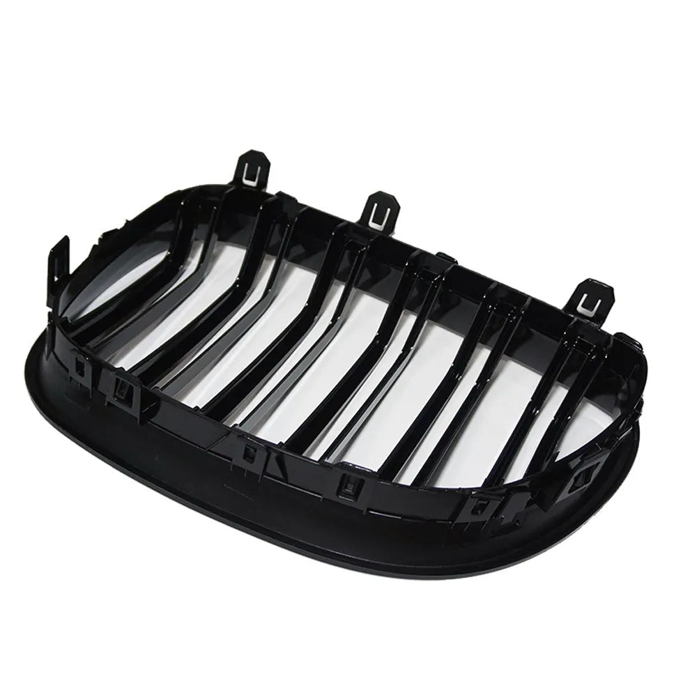 Pair of black carbon fibre pattern front grilles for a BMW 5-Series car.