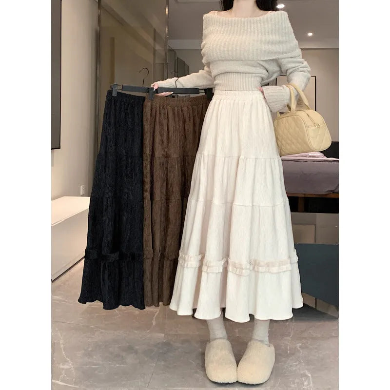Korean-style beige corduroy A-line midi skirt with an elastic waistband laid flat.