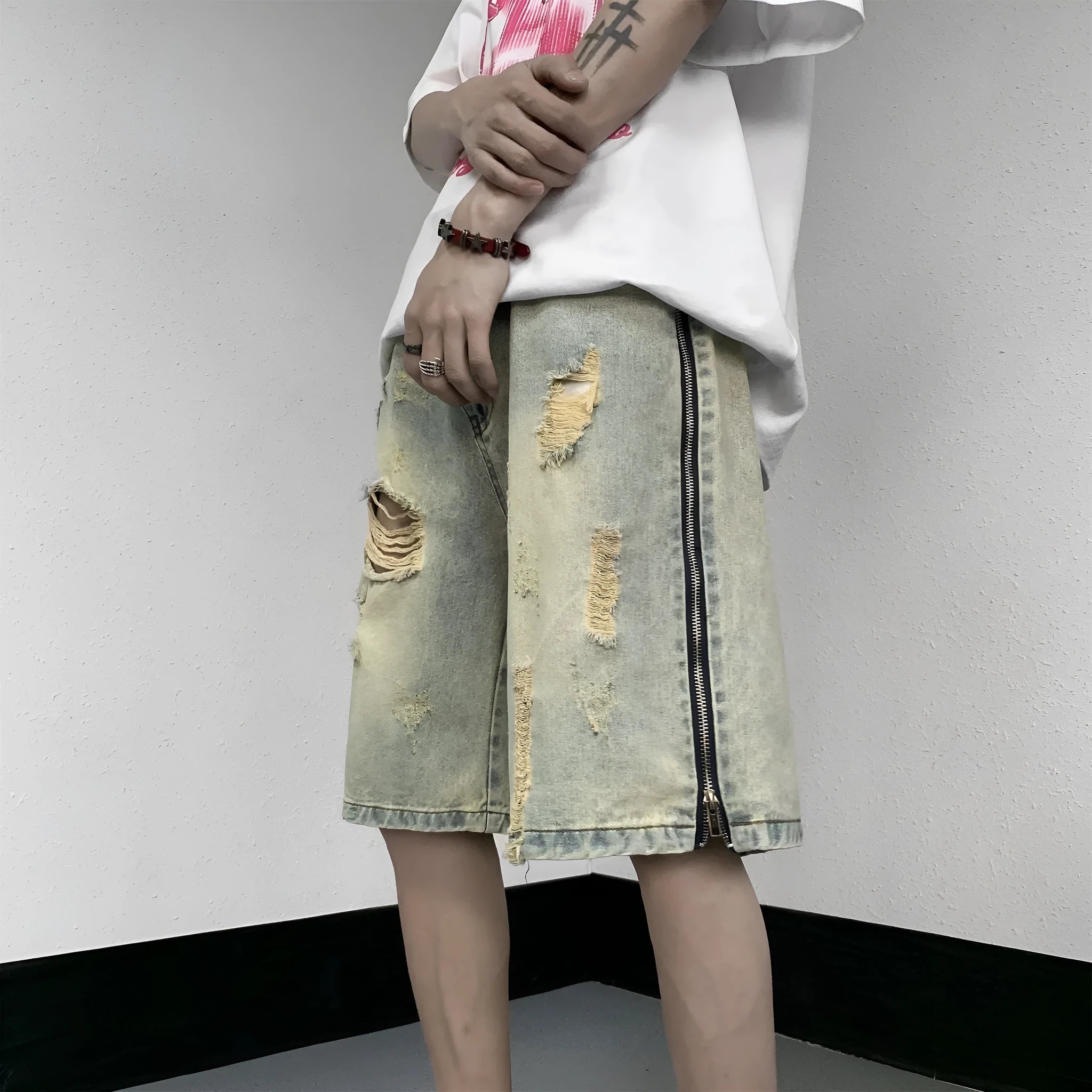 Men's blue denim shorts with a yellow mud distressed finish, rips, loose five-point fit, and button cardigan closure.