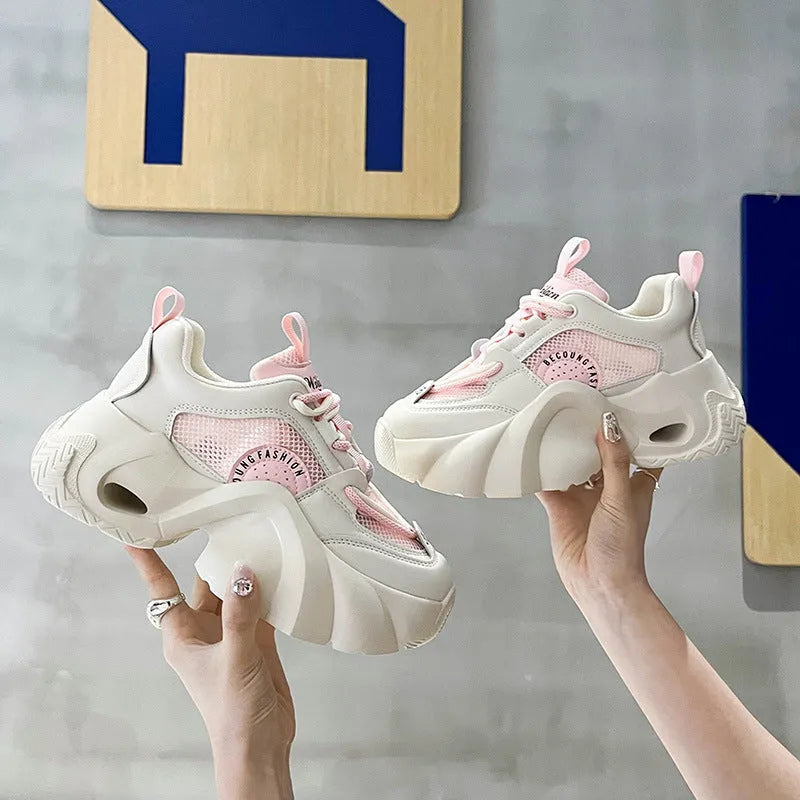 Women's pink casual sneakers with cross shoulder straps and a thick platform sole.