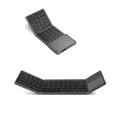 Black tri-fold Bluetooth keyboard unfolded, showing its thin profile and compact size next to a smartphone.