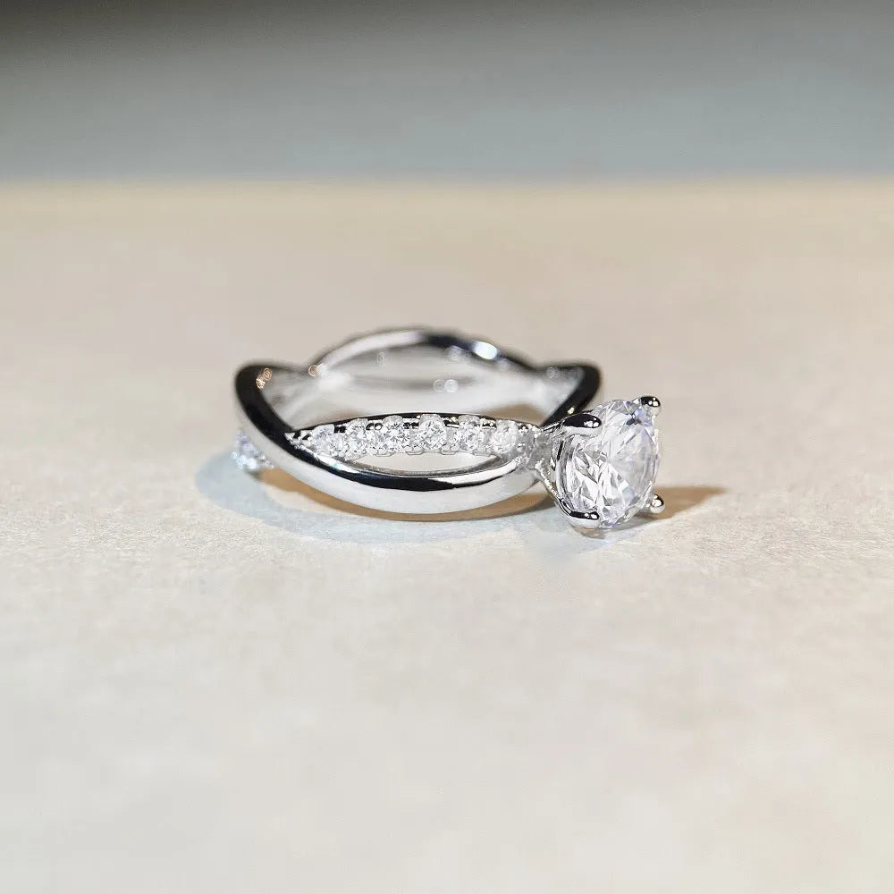 Geometric silver ring with twisted band and a 1 karat moissanite stone in a four-claw setting.
